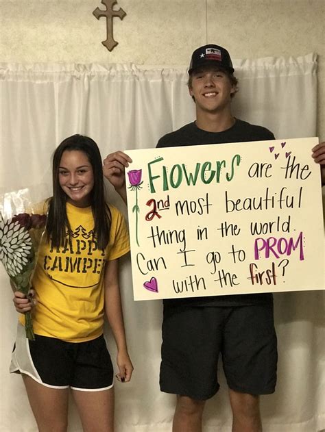 two people standing next to each other holding flowers and a sign that says flowers are the most