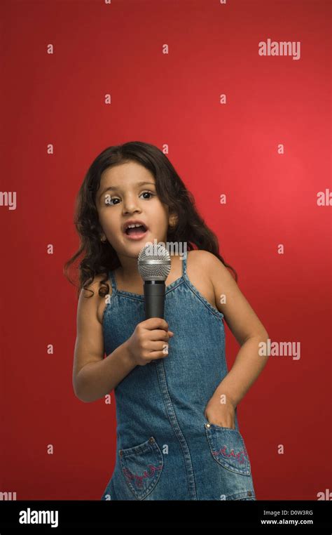 Girl Singing Into A Microphone Stock Photo Alamy