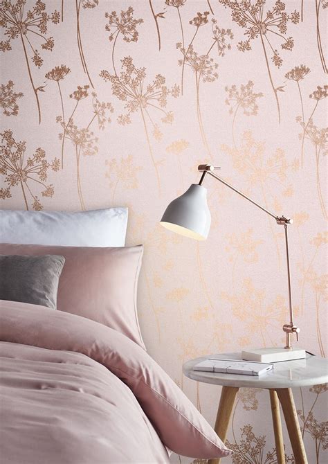 A Bedroom With Pink And Gold Wallpaper A Bed Lamp And Side Table