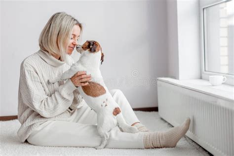 Woman Holds Her Beloved Dog In Her Arms At Home Stock Photo Image Of
