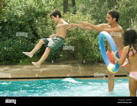Father Throwing Son In Swimming Pool Stock Photo Alamy