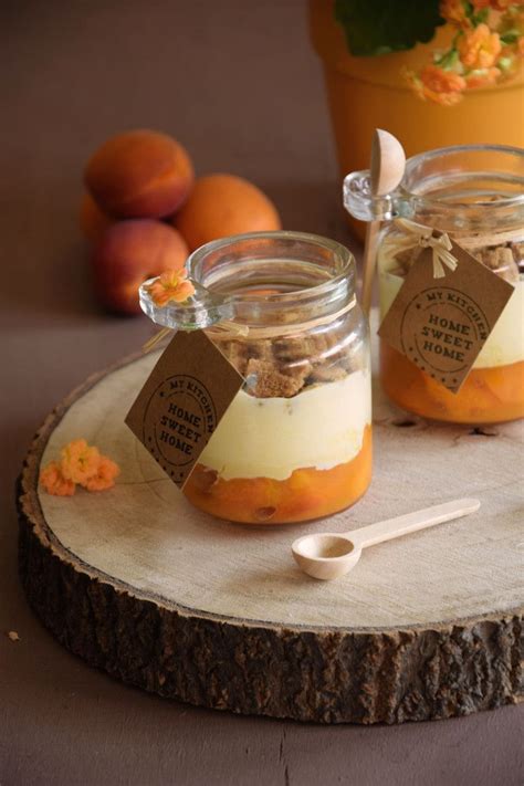 Two Jars Filled With Food Sitting On Top Of A Wooden Table Next To Oranges
