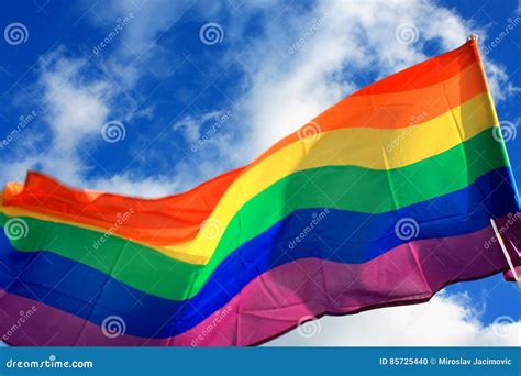 De Beweging Van De Regenboogvlag Lgbt Op De Hemelachtergrond Stock Foto Image Of Vier