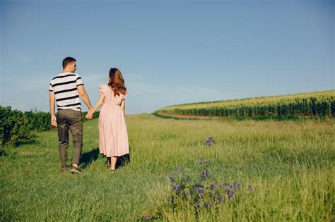 lindo casal passa o tempo em um campo de verão foto grátis