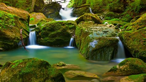 Small Waterfalls On A Mountain River Large Green Rocks With Moss