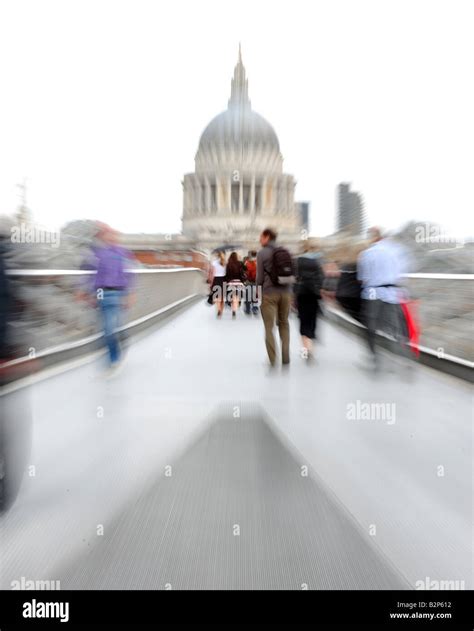 People Walking Over The Millennium Bridge With St Pauls Cathedral In
