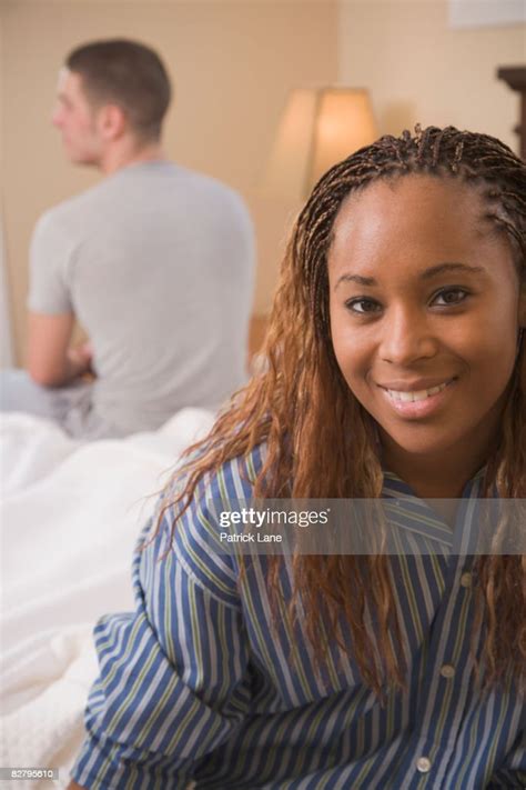 Multiethnic Couple Sitting On Opposite Edges Of Bed High Res Stock
