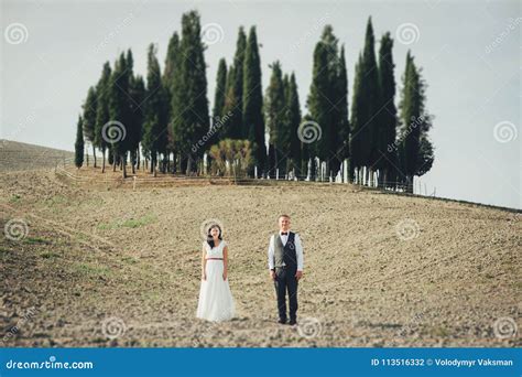 happy stylish smiling couple walking and kissing in tuscany ita stock