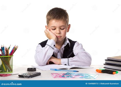 Cute Bored Pupil Sitting With Lowered Eyes At The Desk With Hand Under