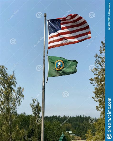United States Flag Waves On Flagpole Underneath It Is Washington State