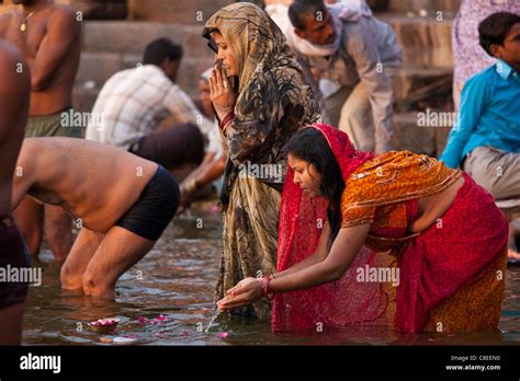 Indian Hindu Pilgrim Bathing And Praying In The Ganges River At