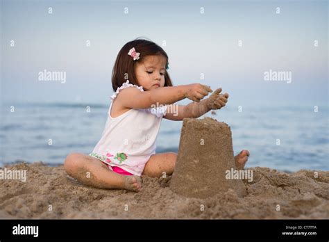 Young Girl Making A Sand Castle On The Beach In The Late Evening Stock