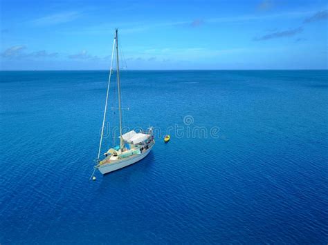 Aerial Shot Of A Sailboat Moored In A Calm Tropical Lagoon Stock Photo