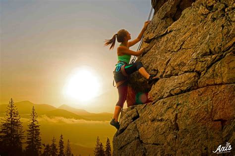 Beautiful Woman Climbing On The Rock At Foggy Sunset In The Mountains