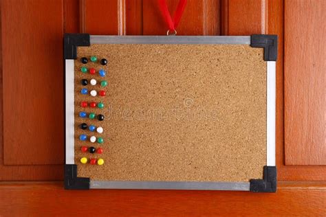 Cork Board With Colorful Push Pins Hanging By A Door Stock Image