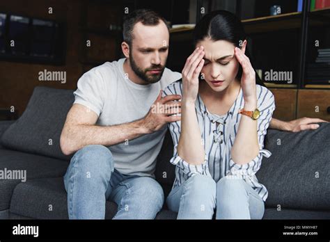 Husband Asking Forgiveness From Wife After Quarrel At Home Stock Photo