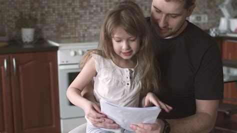 Daughter Sitting On The Lap Of The Father Dad And Little Girl Talking