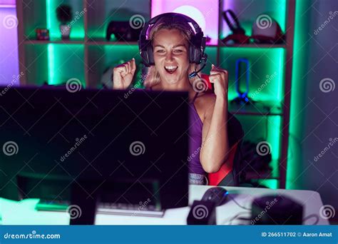 Young Blonde Woman Streamer Playing Video Game With Winner Expression