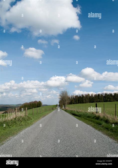 Single Lane Country Road Through Countryside And Farmland Stock Photo