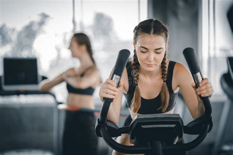Attractive Woman Biking In The Gym Exercising Legs Doing Cardio Workout Cycling Bikes Fitness