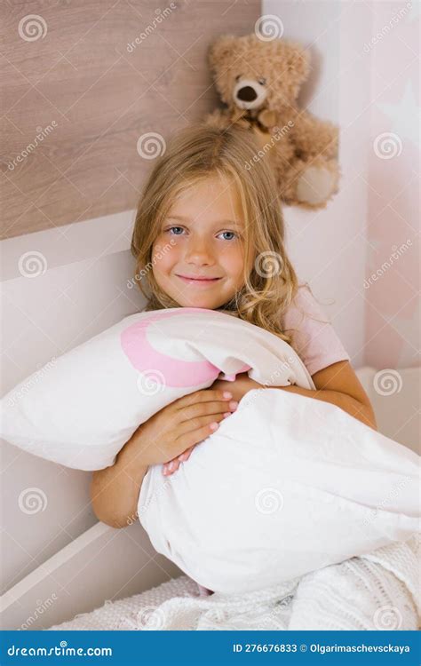 Cute Long Haired Girl Is Sitting On The Bed And Hugging A Pillow Stock Image Image Of Joyful