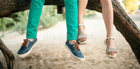 Little Girl And Boy Sit Side By Side On Tree Branch Stock Photo