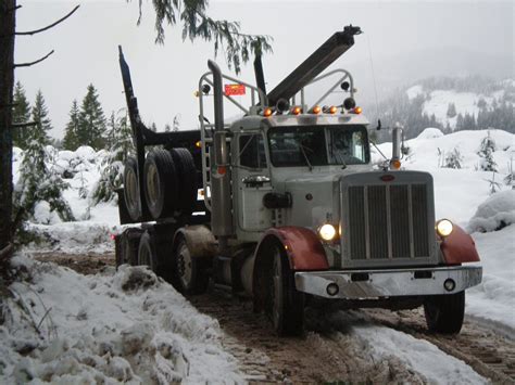 A Large Truck Driving Down A Snow Covered Road