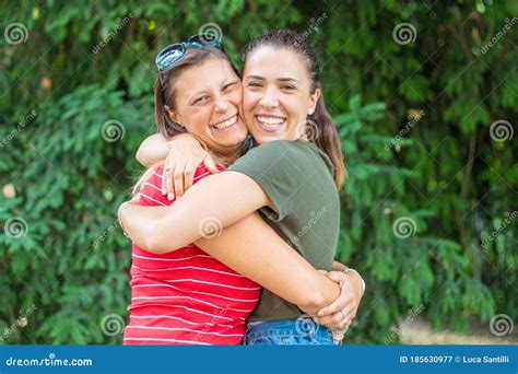 porträt von zwei jungen schönen lesben lächelnden mädchen umarmen sich in ein sommertageswhit