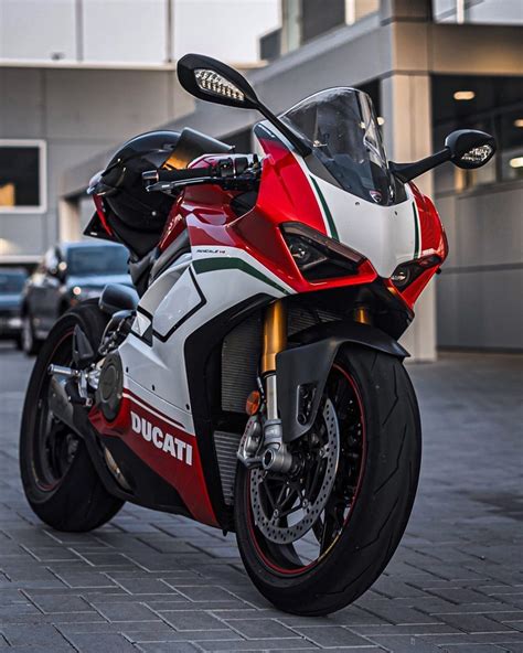 A Red White And Black Motorcycle Parked In Front Of A Building On The