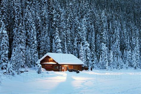 A Snow Covered Log Cabin On A Snow Covered Lakeshore