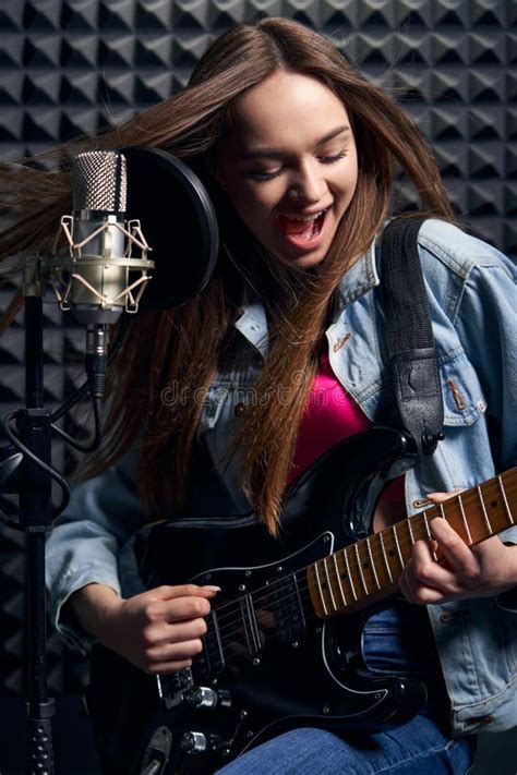Girl Musician In Recording Studio Playing Electric Guitar And Singing
