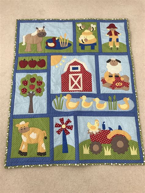 A Quilt With Farm Animals And Farm Scenes On It