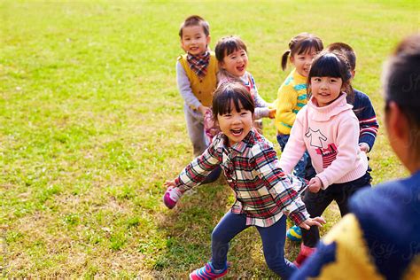 Happy Asian Kids Playing Outdoor In The Park Stocksy United