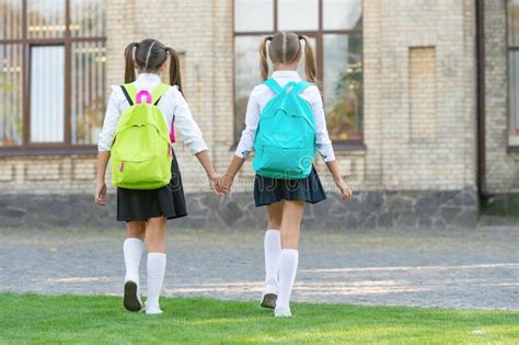 Back View Of Two Schoolgirls With School Backpack Walking Together Outdoor With Copy Space Stock