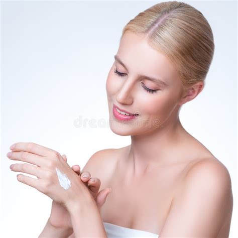 Personable Woman Applying Moisturizer Cream On Her Han In Isolated