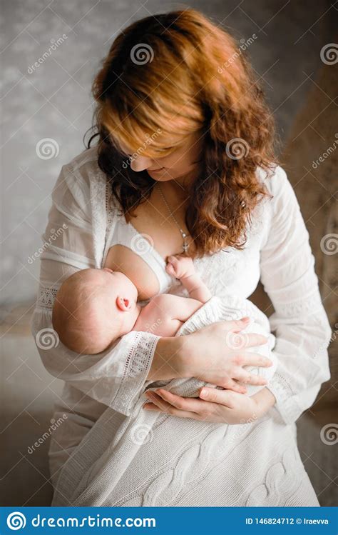 Breast Feeding Red Haired Beautiful Mother Breastfeeds A Newborn Baby