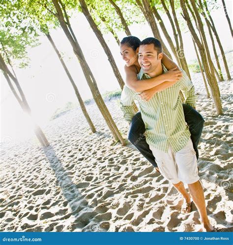 Man Giving His Girlfriend Piggyback Ride In The Park Stock Image