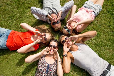 Group Of Smiling Friends Lying On Grass Outdoors Stock Image Colourbox