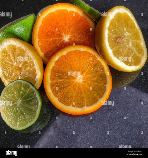Oranges Lemons And Limes Sliced On A Reflective Surface Stock Photo Alamy