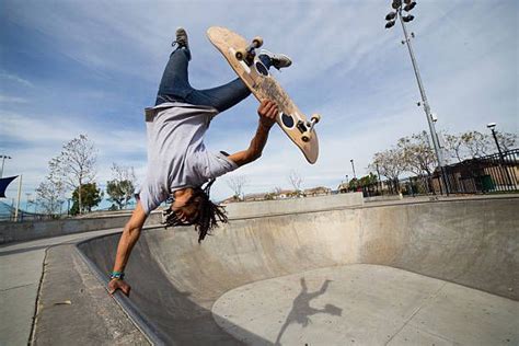 Young Man Doing Skateboard Trick Upside Down On Edge Of Skateboard