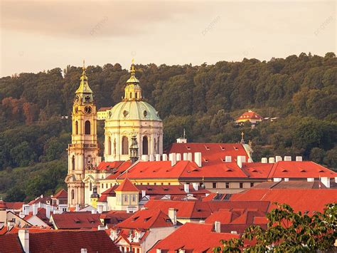 プラハの聖ニコラス教会はチェコ共和国の魅力的な小さな町の街並みを支配しています 写真背景 無料ダウンロードのための画像 Pngtree