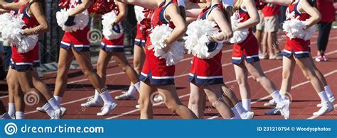 Cheerleaders Cheering On The Sidelines Oduring A High School Football