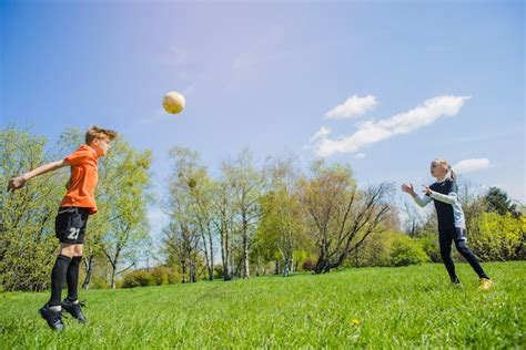 Niños Jugando Al Fútbol En El Parque Foto Gratis