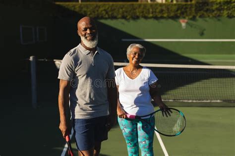 Portrait Of Smiling Senior African American Couple With Tennis Rackets