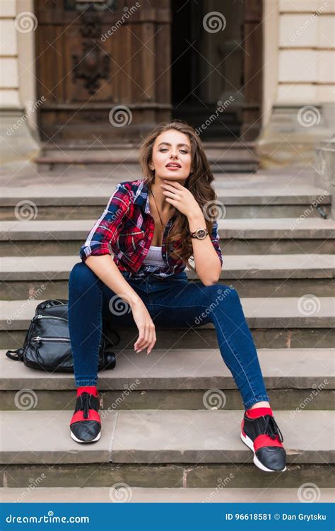 Portrait Of A Beautiful Young Woman Sitting On Stairs Outdoors