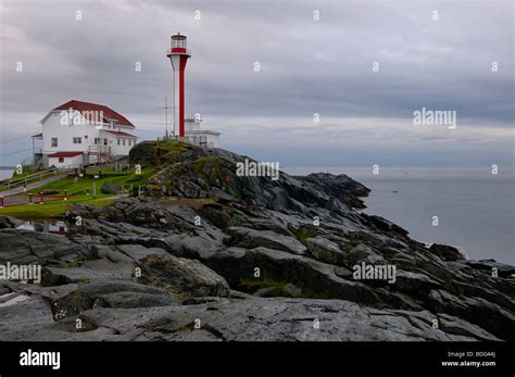 Cape Forchu Lighthouse On The Atlantic Ocean With Clouds And Wet Rocks