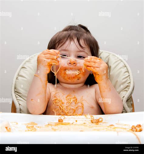 Happy Baby Having Fun Eating Messy Covered In Spaghetti Holding Angel