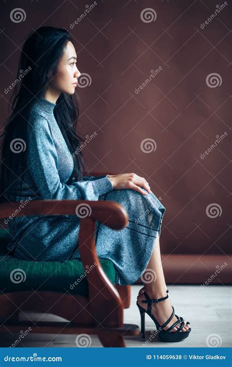 Profile Portrait Of Asian Beautiful Woman Sitting In Chair Stock Photo