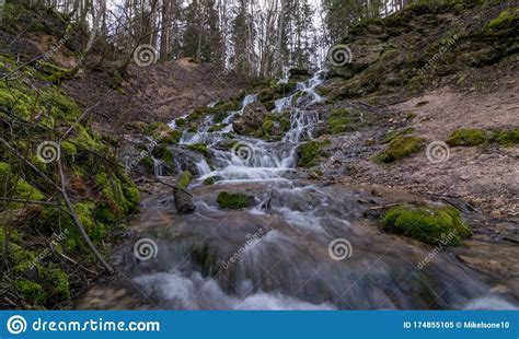 A Stream Of Water Flowing Over Rocks And Creating A