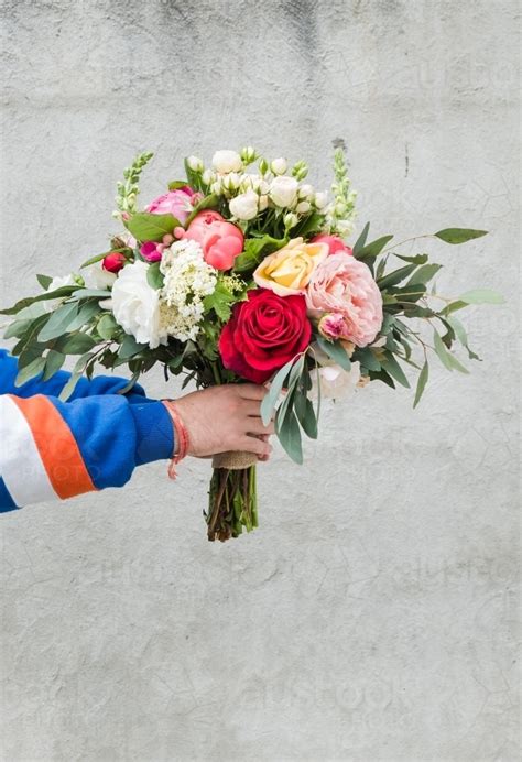 Some men carry them that way in public because they think it makes them less girly some people carry them that way to prevent the sap from running out. Image of hands holding a bouquet of flowers. - Austockphoto